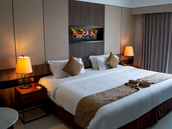 A well-decorated hotel room with a large bed, two lamps, and a window with curtains, creating a cozy atmosphere.